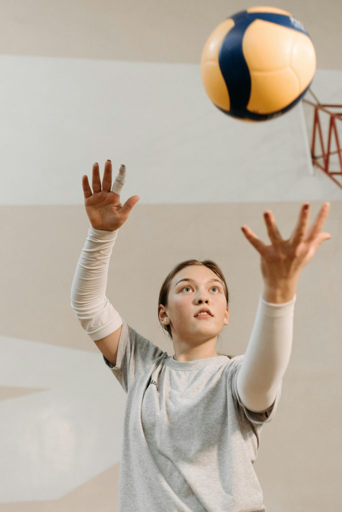 Femme jetant une balle en l'air pour la frapper